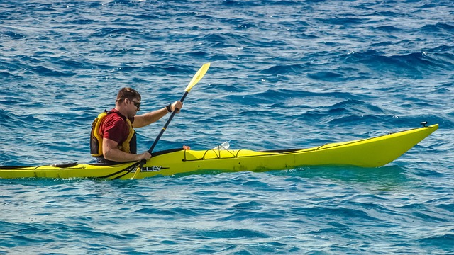 man paddling colorful kayak