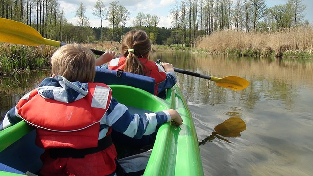 children share a kayak