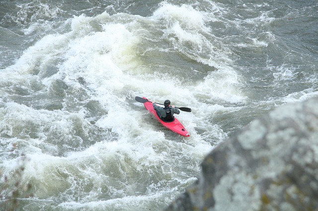 Surging whitewater river with red kayak